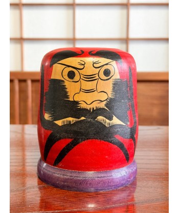 Kokeshi Daruma de Kamata Koichi sur son socle violet ouvre sa boutique