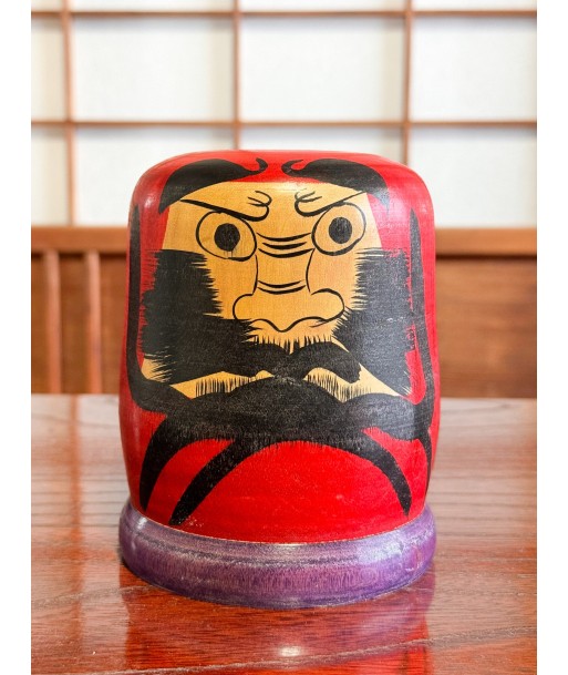 Kokeshi Daruma de Kamata Koichi sur son socle violet ouvre sa boutique