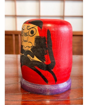 Kokeshi Daruma de Kamata Koichi sur son socle violet ouvre sa boutique