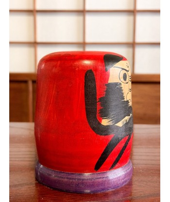 Kokeshi Daruma de Kamata Koichi sur son socle violet ouvre sa boutique