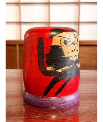 Kokeshi Daruma de Kamata Koichi sur son socle violet ouvre sa boutique